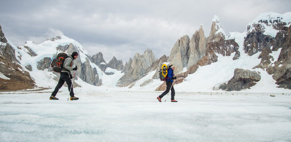 The author and partner, Brinannala Morgan walk across the meltwater pools on the surface of the Campo de Heilo Norte with the Torres and the Circo de los Altares in the background.